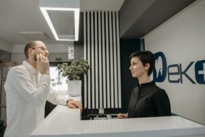 Patient discussing dental issues at a modern clinic reception with a receptionist.