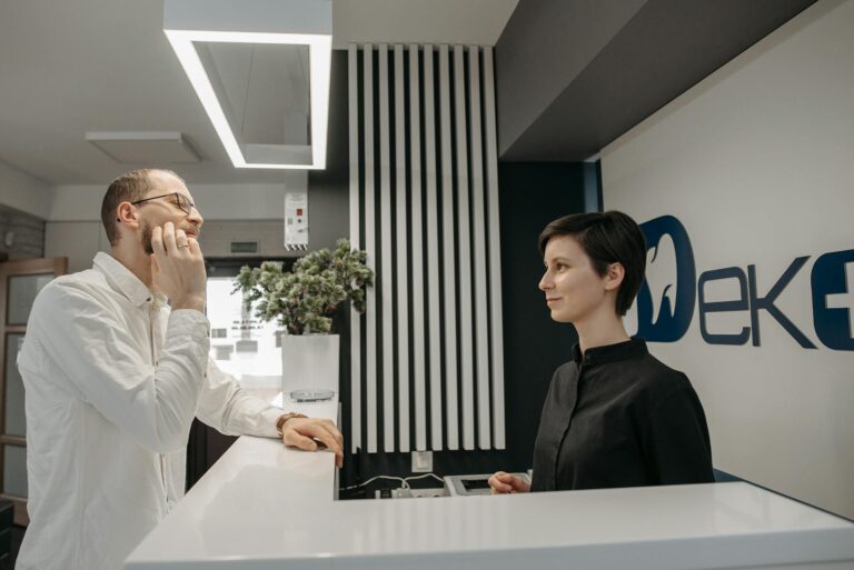 Patient discussing dental issues at a modern clinic reception with a receptionist.
